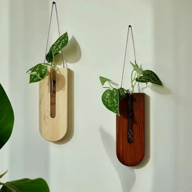 Two wooden hanging planters with vertical slots in light natural and dark finishes, each holding pothos.