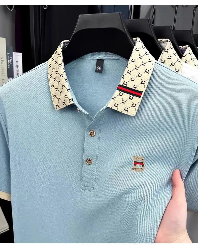 Simples Market polo shirt, light blue short-sleeve with beige patterned collar, red stripe, and B logo embroidery.