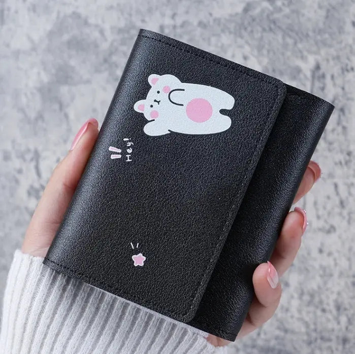 Wallet with black faux leather and cute white bunny print with pink cheeks, held in hand