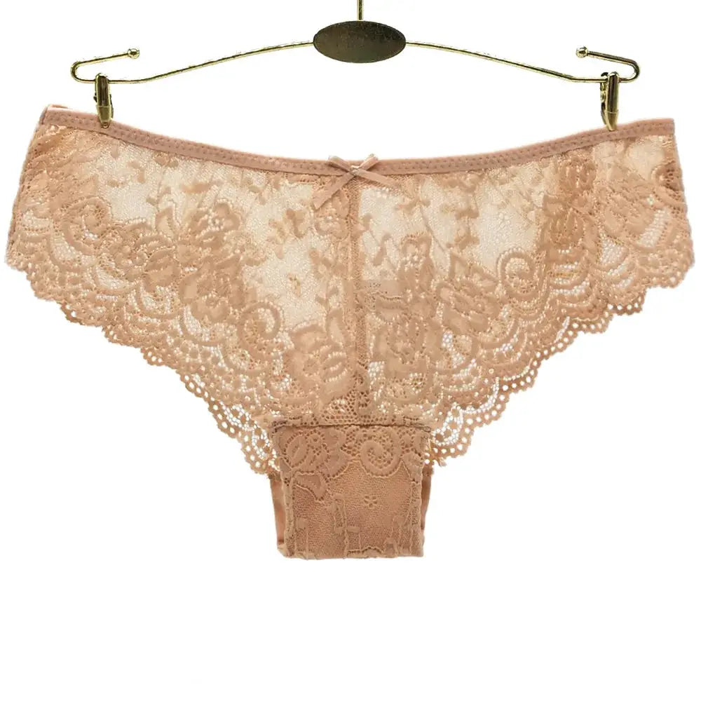 Women's peach lace thong panties with floral pattern and bow, hanging on a hanger