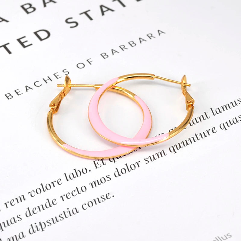 Hoop earrings by Simples Market, gold-tone with pink enamel oval pendant.