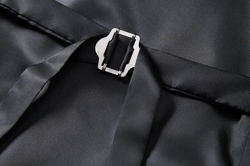 Men's black waistcoat fabric close-up with metal clasp detail