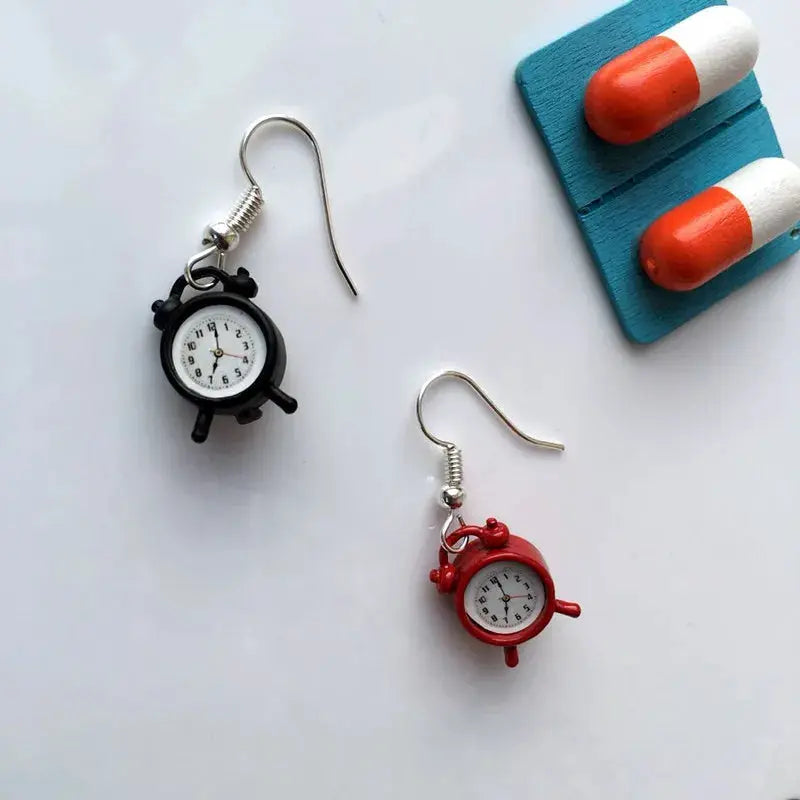 Pair of clock earrings with black and red miniature alarm clocks on silver hooks.