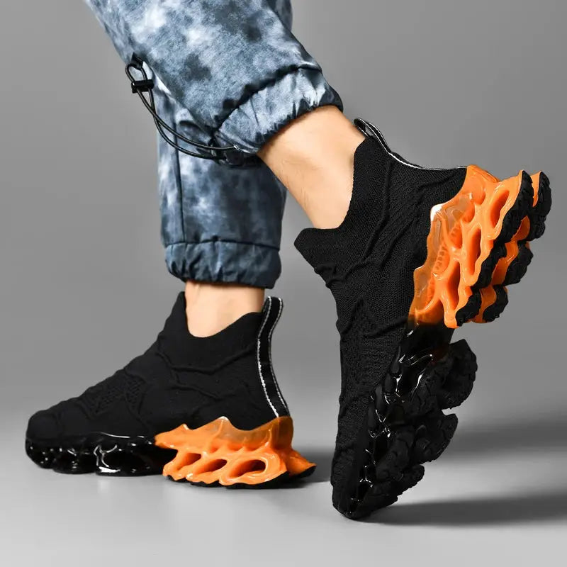 Pair of men's black knit sneakers with orange segmented outsole