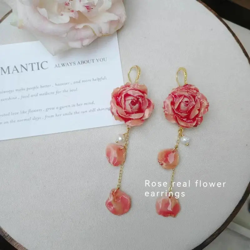 Elegant Immortal Rose long earrings pair by Simples Market with pink rose blooms and epoxy resin petals on gold chains