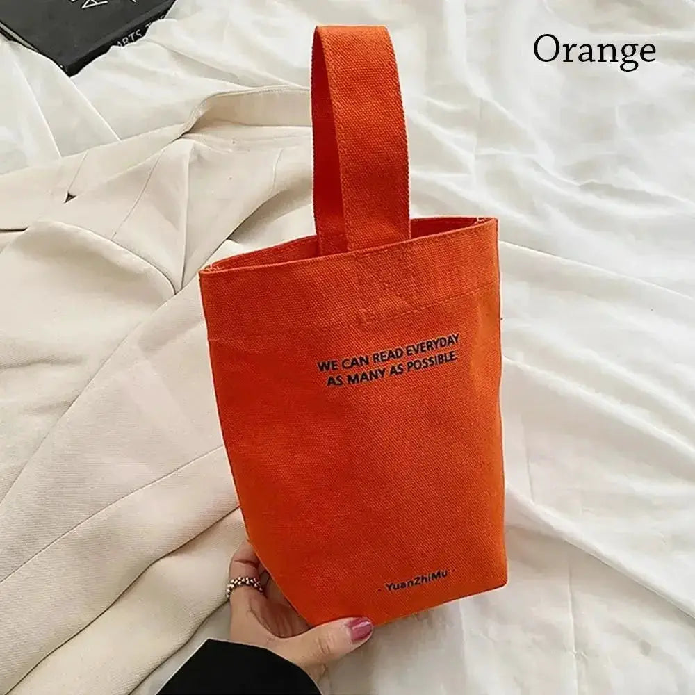 Canvas tote bag in orange with top handle, large-capacity casual shopper purse featuring slogan text