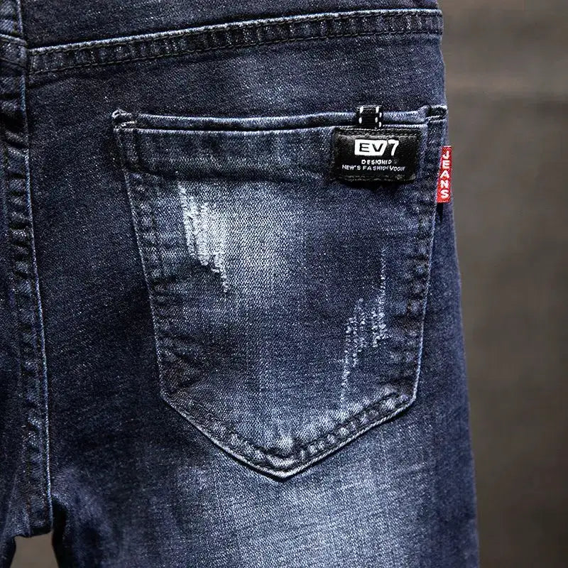 American elastic-straight jeans for men in blue denim with distressed pocket and EV7 tag.