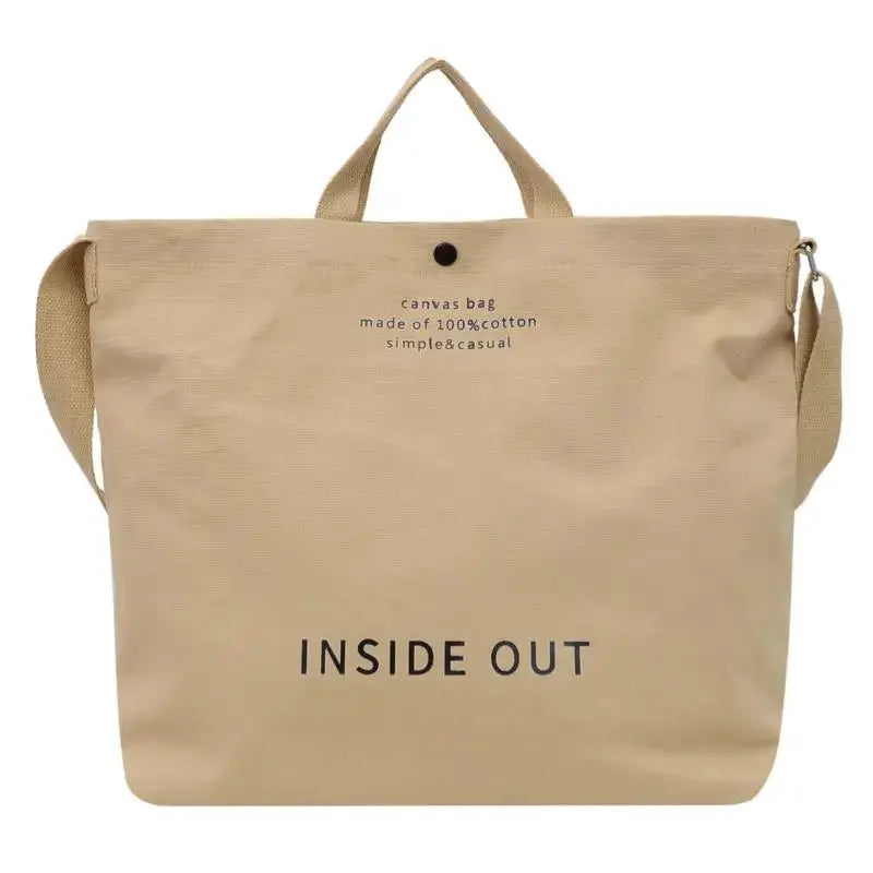 Canvas crossbody bag in beige with top handle and adjustable shoulder strap; large capacity.