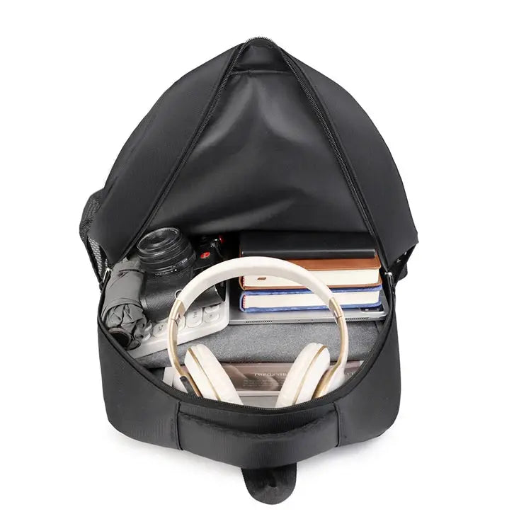 Simples Market black travel backpack opened to show large-capacity main compartment with books and headphones