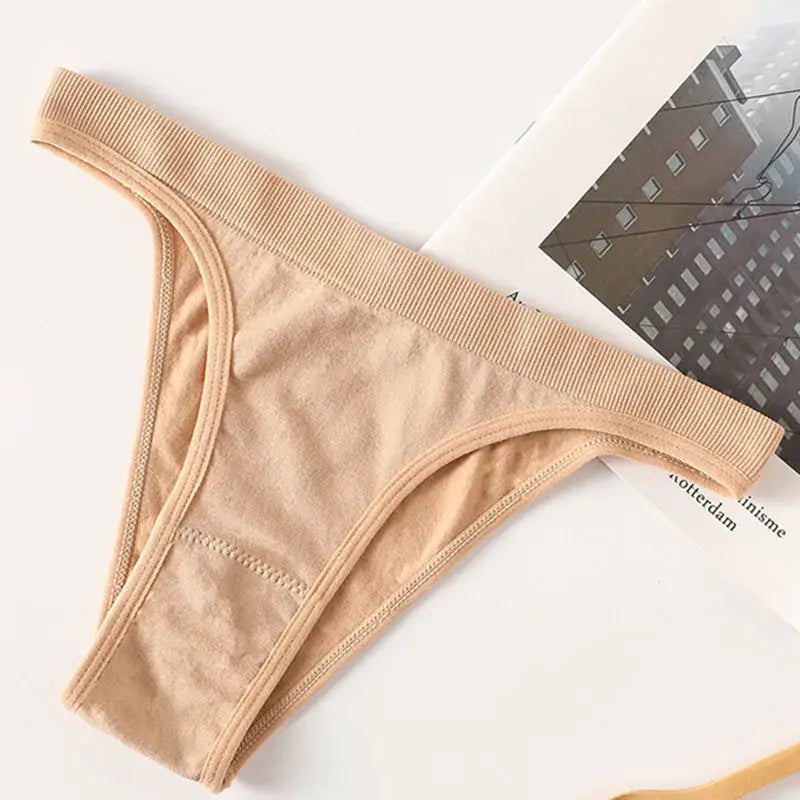 Women ribbed low-rise thong underwear in nude, breathable cotton gusset, high-leg cut.