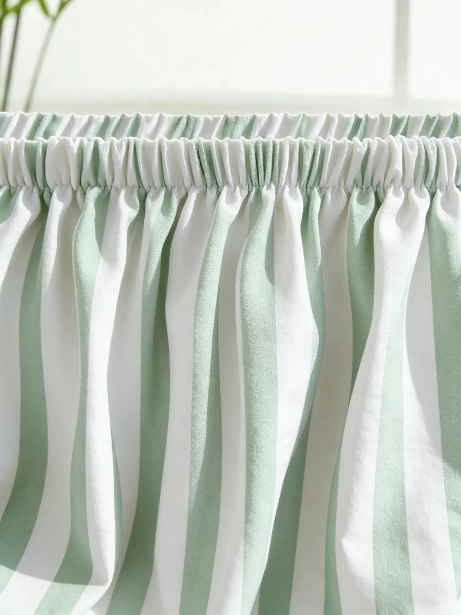 Sofa protective cover by Simples Market in mint green and white stripes with elastic edge.