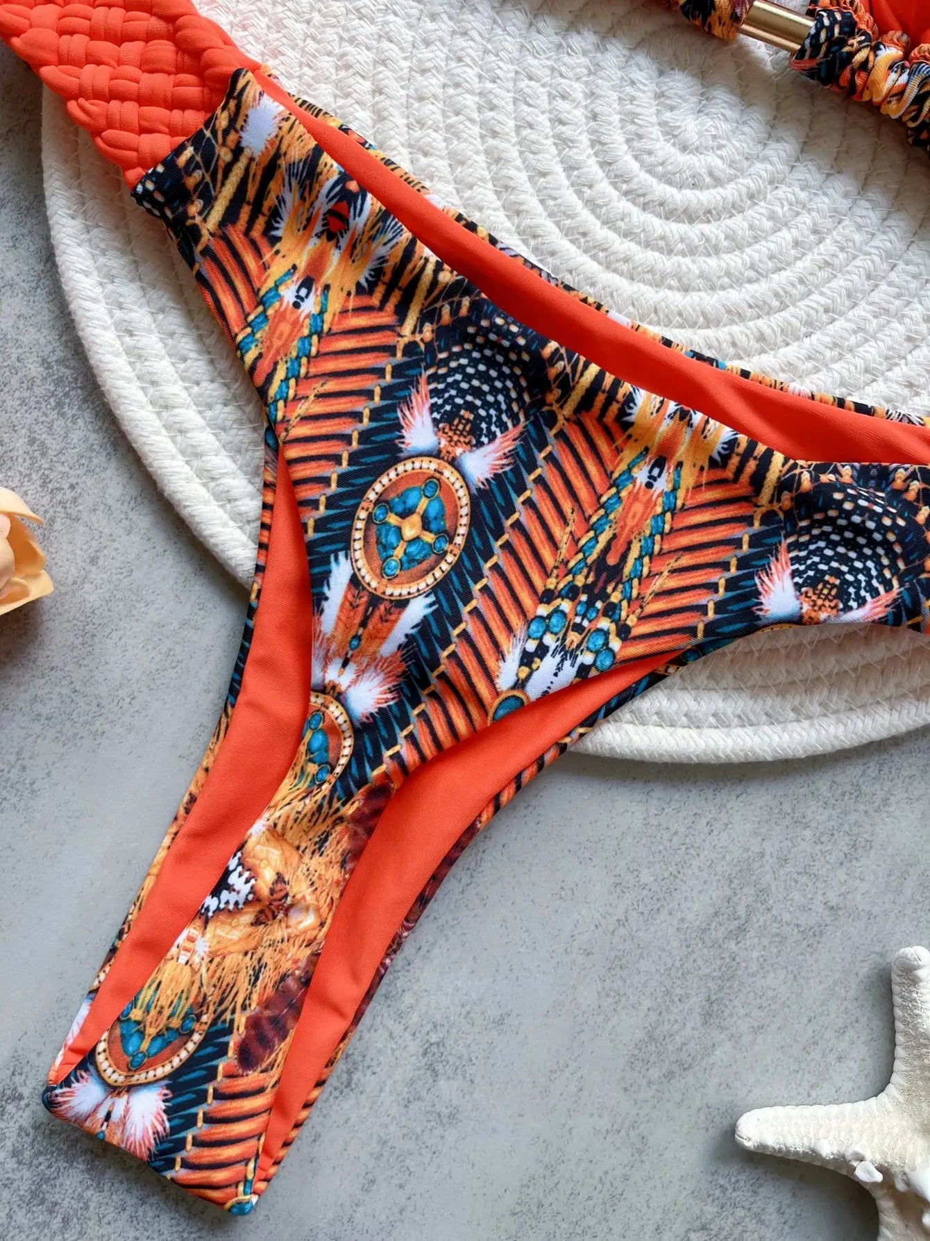 High-cut bikini bottom with vibrant geometric print and orange trim; two-piece swimsuit set