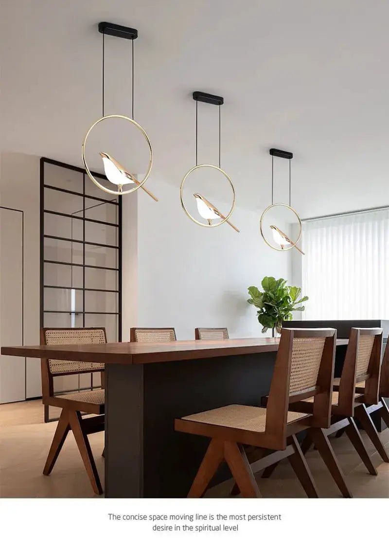 Rotatable magpie bird LED pendant lights with gold circular frames; set of 3 over a dining table