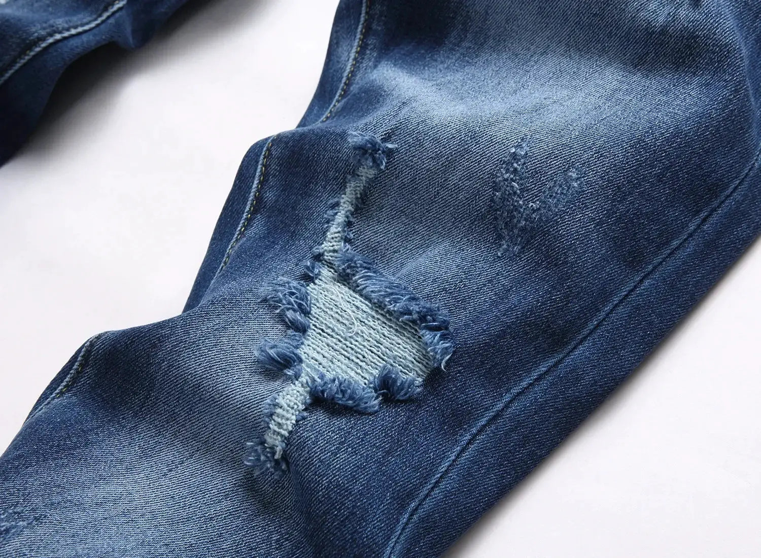 Men's ripped jeans by Simples Market, light blue denim with knee distress and frayed patch, slim stretch fit