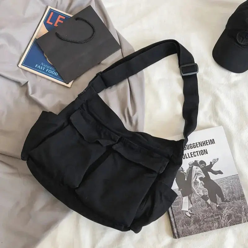 Black canvas women's messenger bag with adjustable shoulder strap, front pockets and large capacity