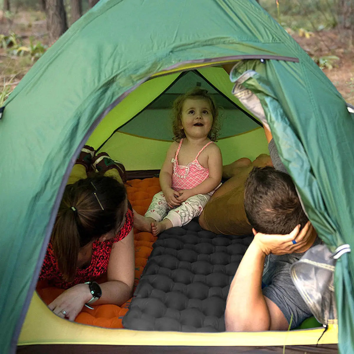 Simples Market inflatable sleeping pad for camping; orange/gray quilted mat inside a green tent