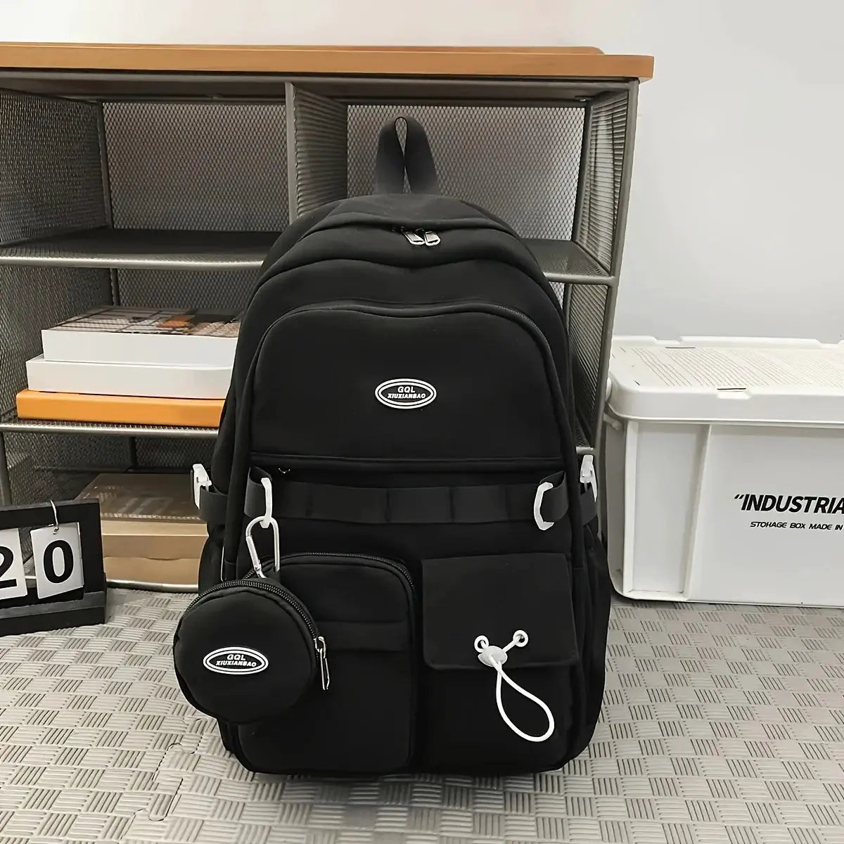 Backpack by Simples Market, black large-capacity sports travel bag with front pockets and a small round pouch.