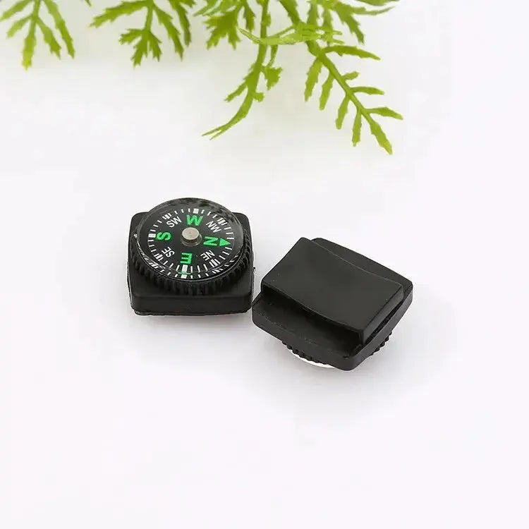 Small outdoor compass by Simples Market; black plastic housing with green dial and removable cap.