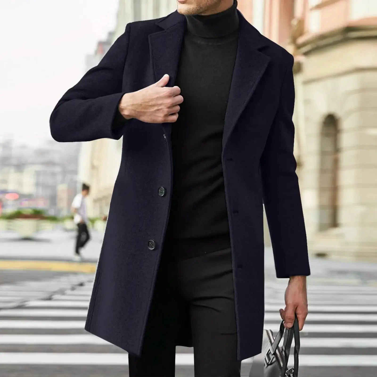 Men's navy wool-blend trench coat worn over black turtleneck on city street backdrop