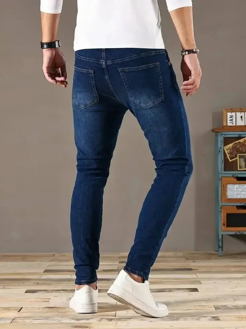 Men's blue denim slim-fit jeans with back pockets, casual street style.