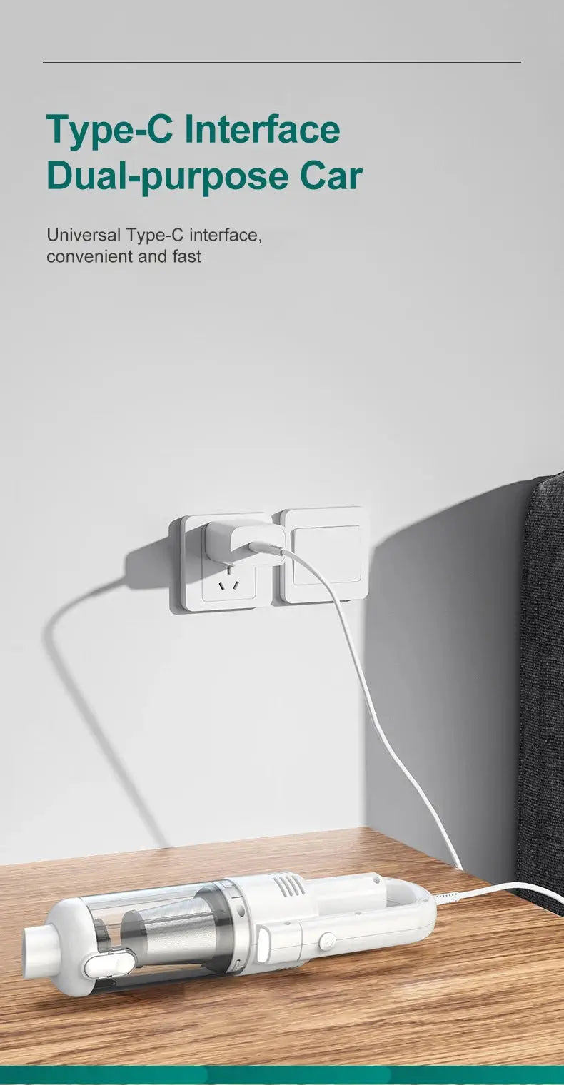 Handheld vacuum cleaner, white with transparent dust chamber, placed on a wooden table and plugged into a wall outlet.