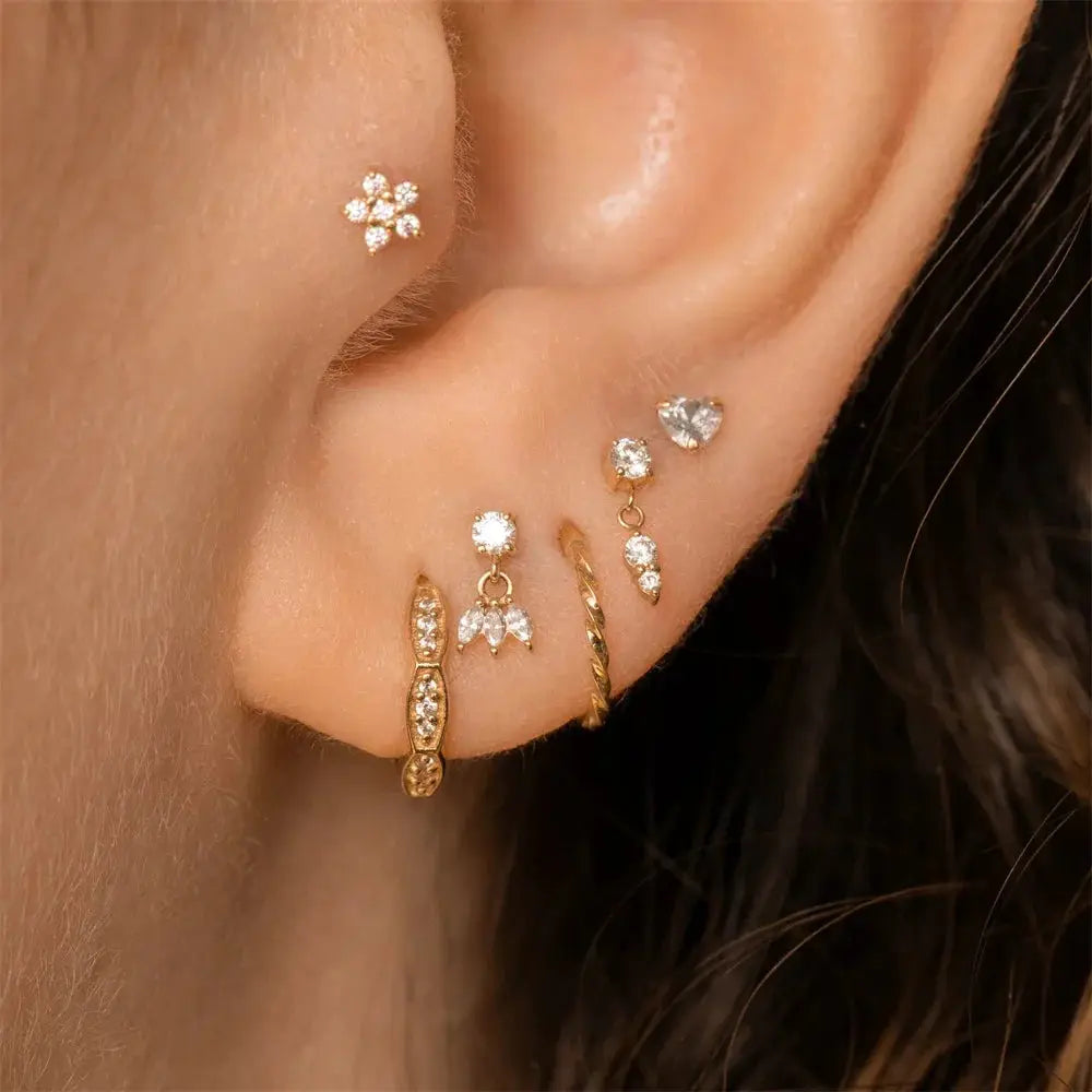 Gold-tone zircon earring set with multiple studs on ear; includes flower, heart and bar designs