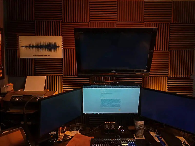 TOUO acoustic foam panels on a studio wall with a multi-monitor setup and desk accessories
