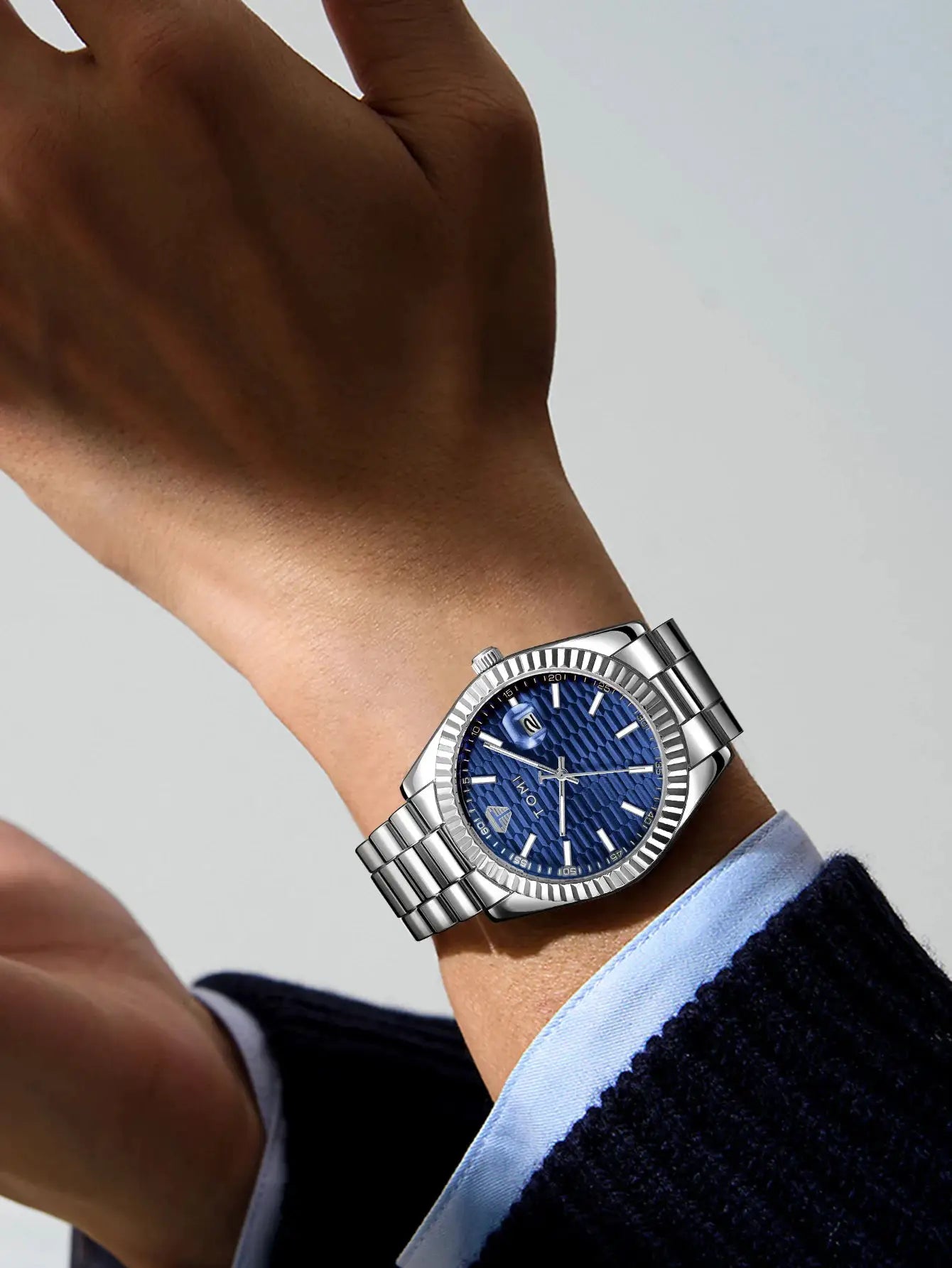 Men's watch with blue textured dial and stainless steel bracelet; calendar date window, luxury business casual style.