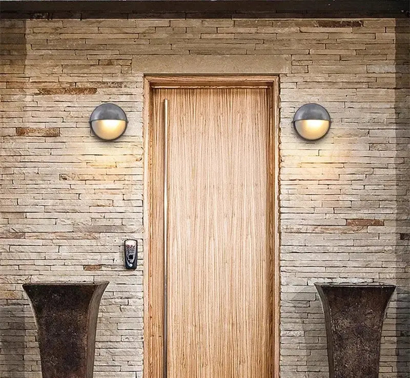 Outdoor retro LED wall lamp pair flanking a wooden door on a stone wall; IP65 waterproof outdoor sconces.