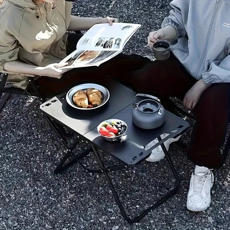 Simples Market portable folding camping table with stainless steel top; outdoor dining with fruit bowls and croissants