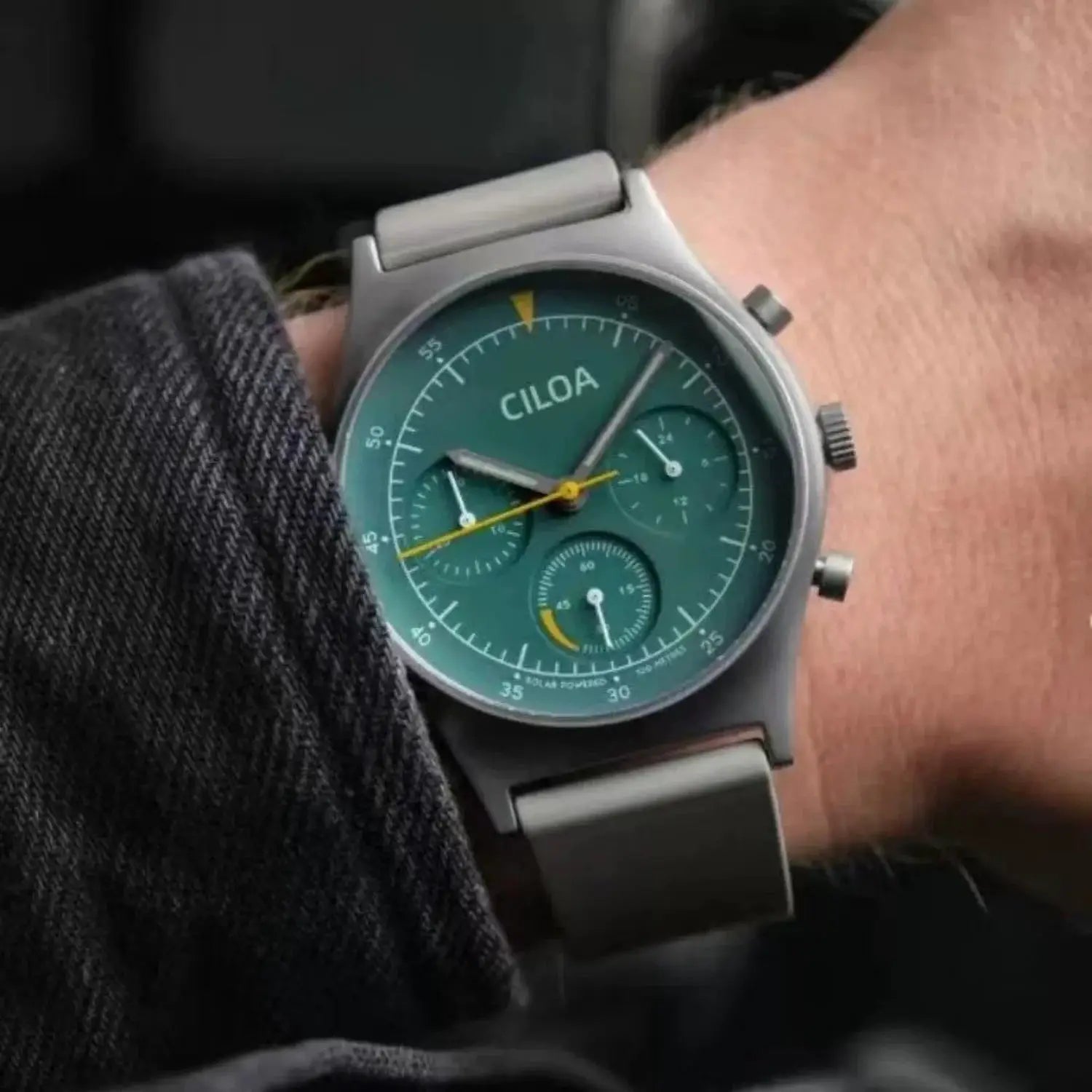 CILOA round gray case men's watch with teal dial and multiple subdials, stainless steel bracelet