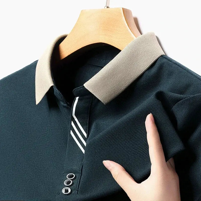 Men's short-sleeve polo shirt by Simples Market, navy with beige collar and striped placket, on hanger.