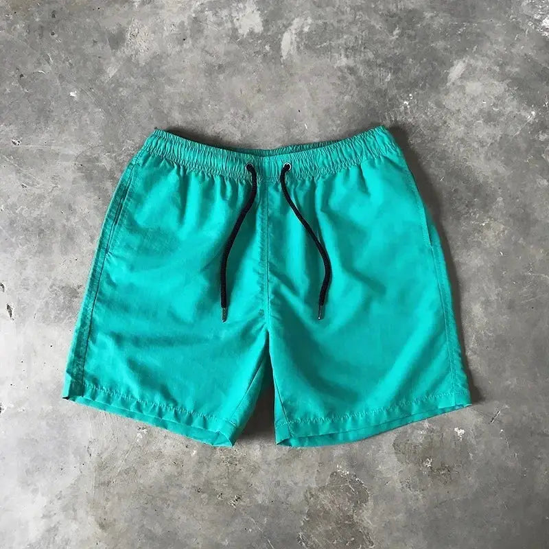 Men's turquoise swim shorts with black drawstring, mid-length trunks