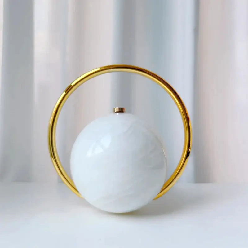 Luxury acrylic ball-handled evening clutch in white marble finish with a gold circular ring handle