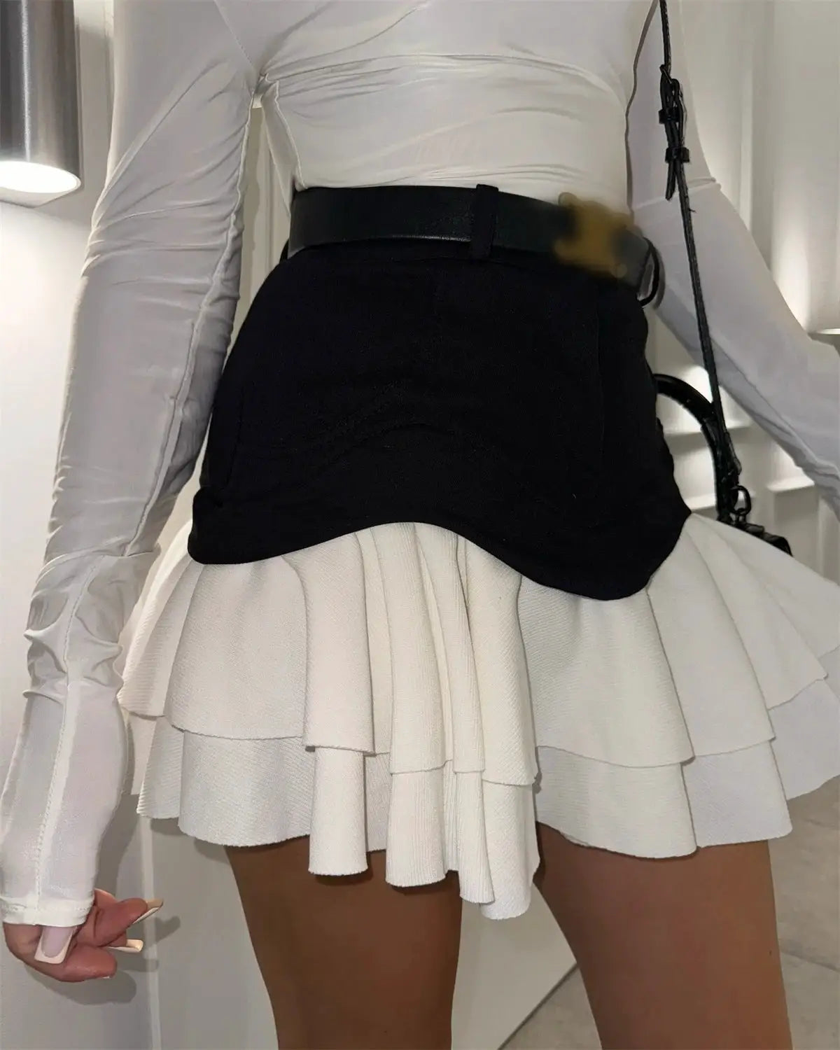 Chic Ruffles white layered skirt with a black high-waisted belt by Simples Market