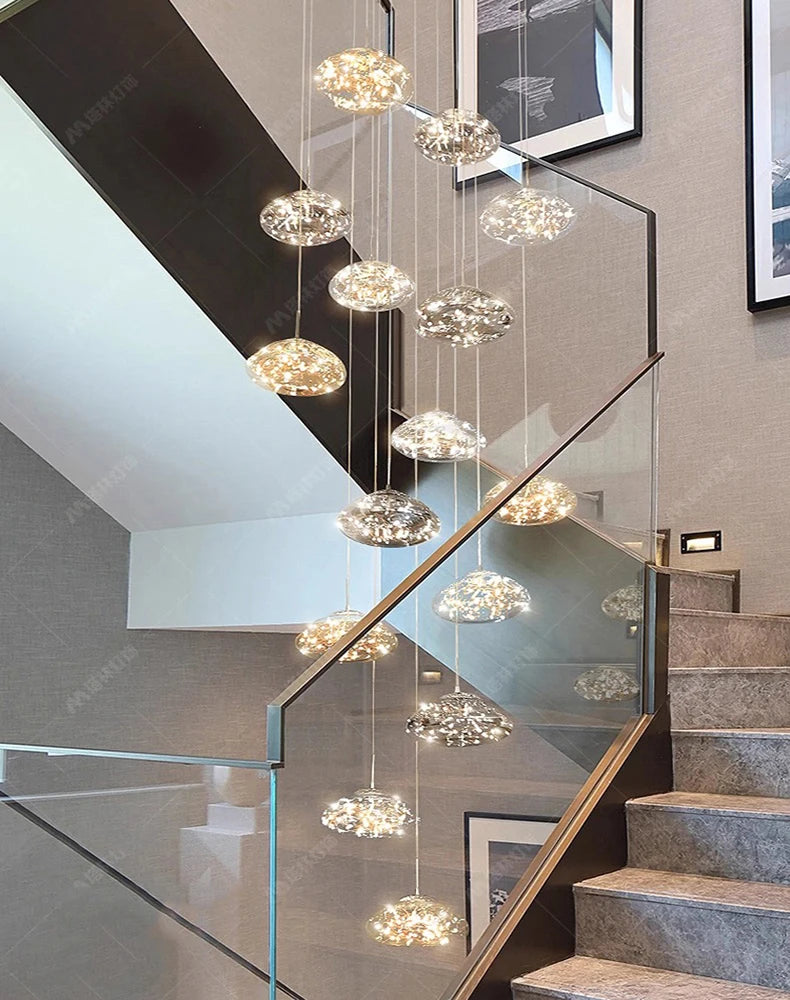 12 pendant lights: cluster of clear bubble glass LED pendants suspended along a modern staircase.