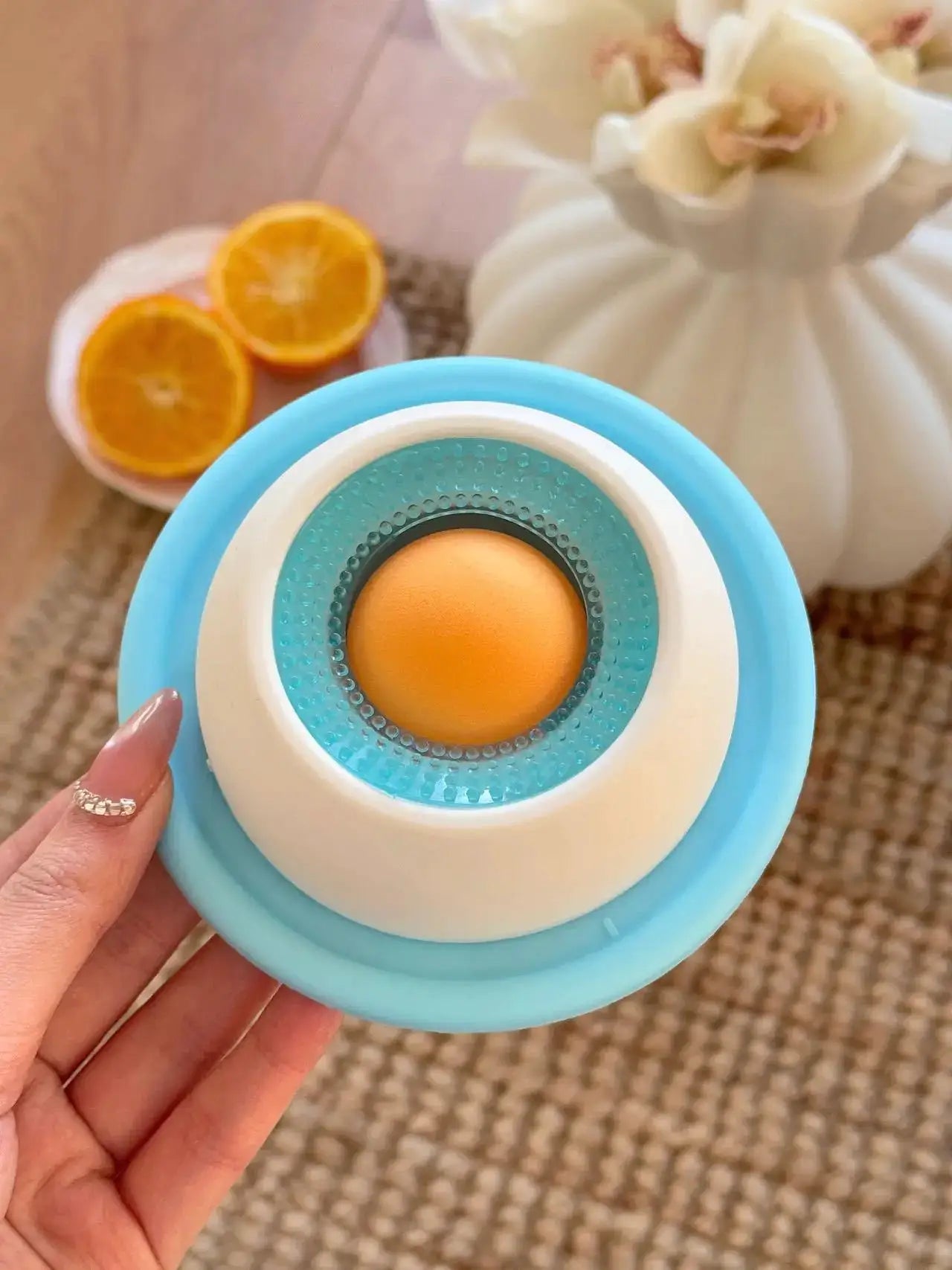 Dog lick toy slow feeder with blue circular base and teal inner ring around orange ball