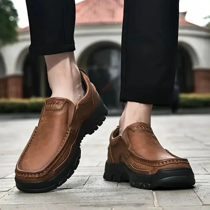 Pair of brown leather men's slip-on loafers with chunky black outsole