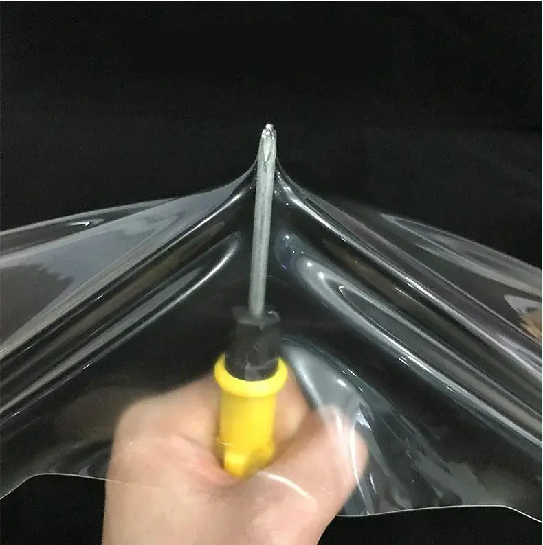 Simples Market PPF clear protection vinyl film, glossy finish, being applied with yellow handle tool