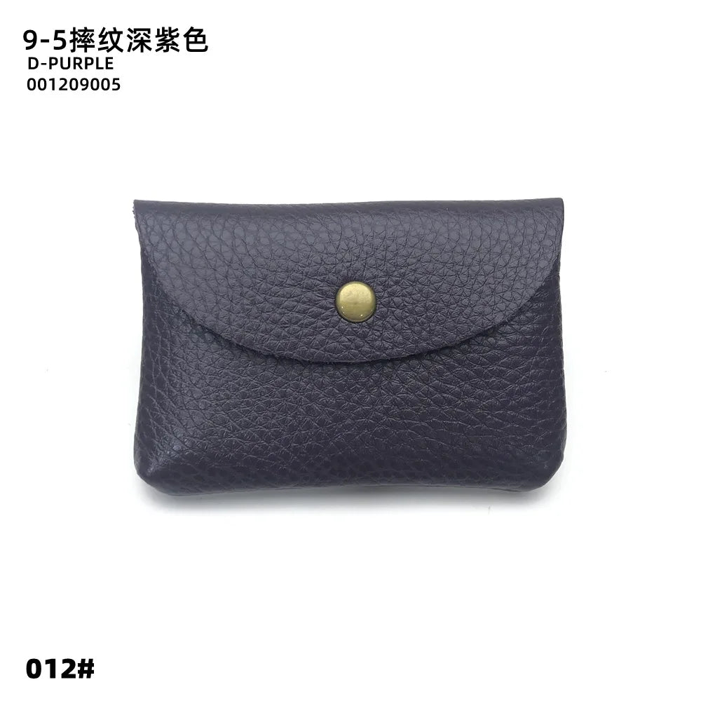 Leather card holder in deep purple pebble-grain cowhide with brass snap, envelope-style.