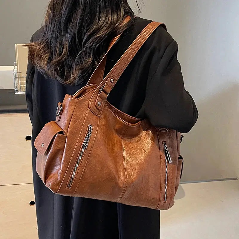 Crossbody bag in cognac PU leather with dual front zipper pockets and top handles