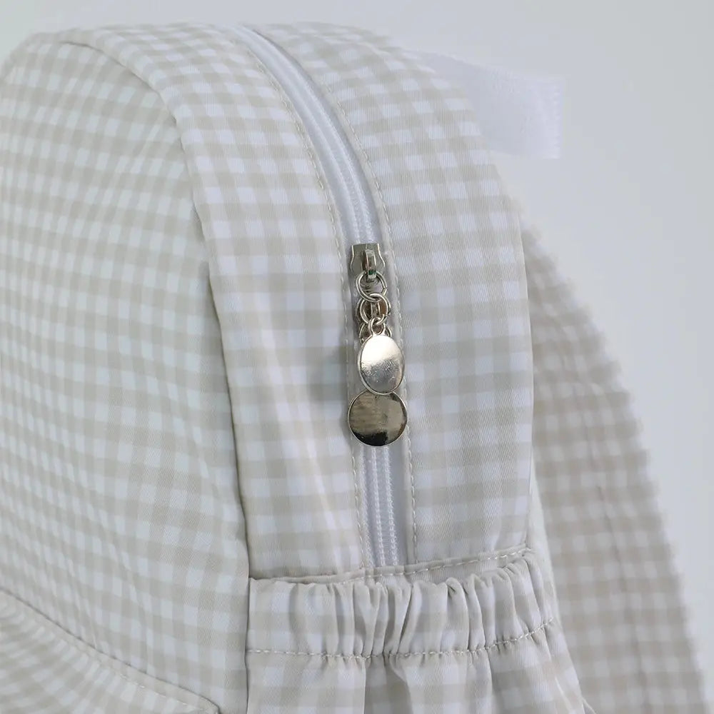 Toddler backpack in beige gingham fabric with white zipper and round metal zipper pulls