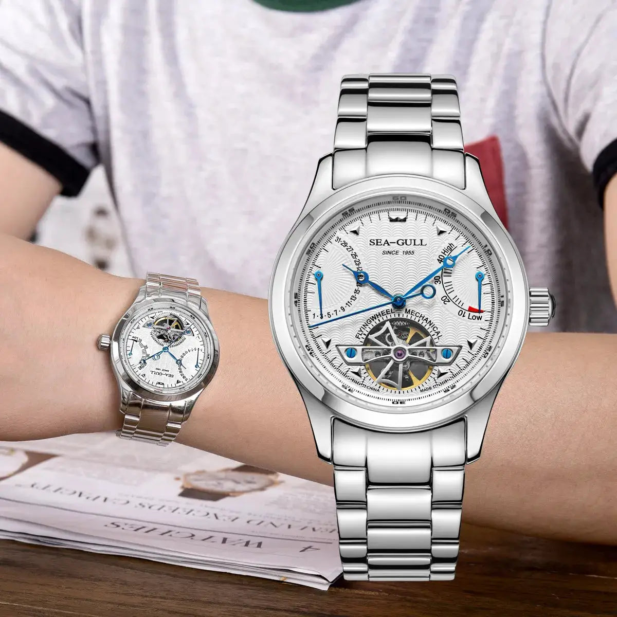 Sea-Gull men's automatic wristwatch with open-heart display and blue hands; stainless steel band; two watches shown.