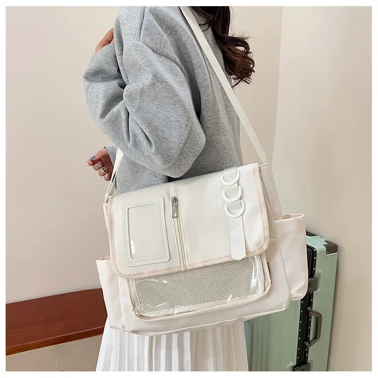White itabag crossbody bag with transparent front panel, badge display area, and mesh pocket