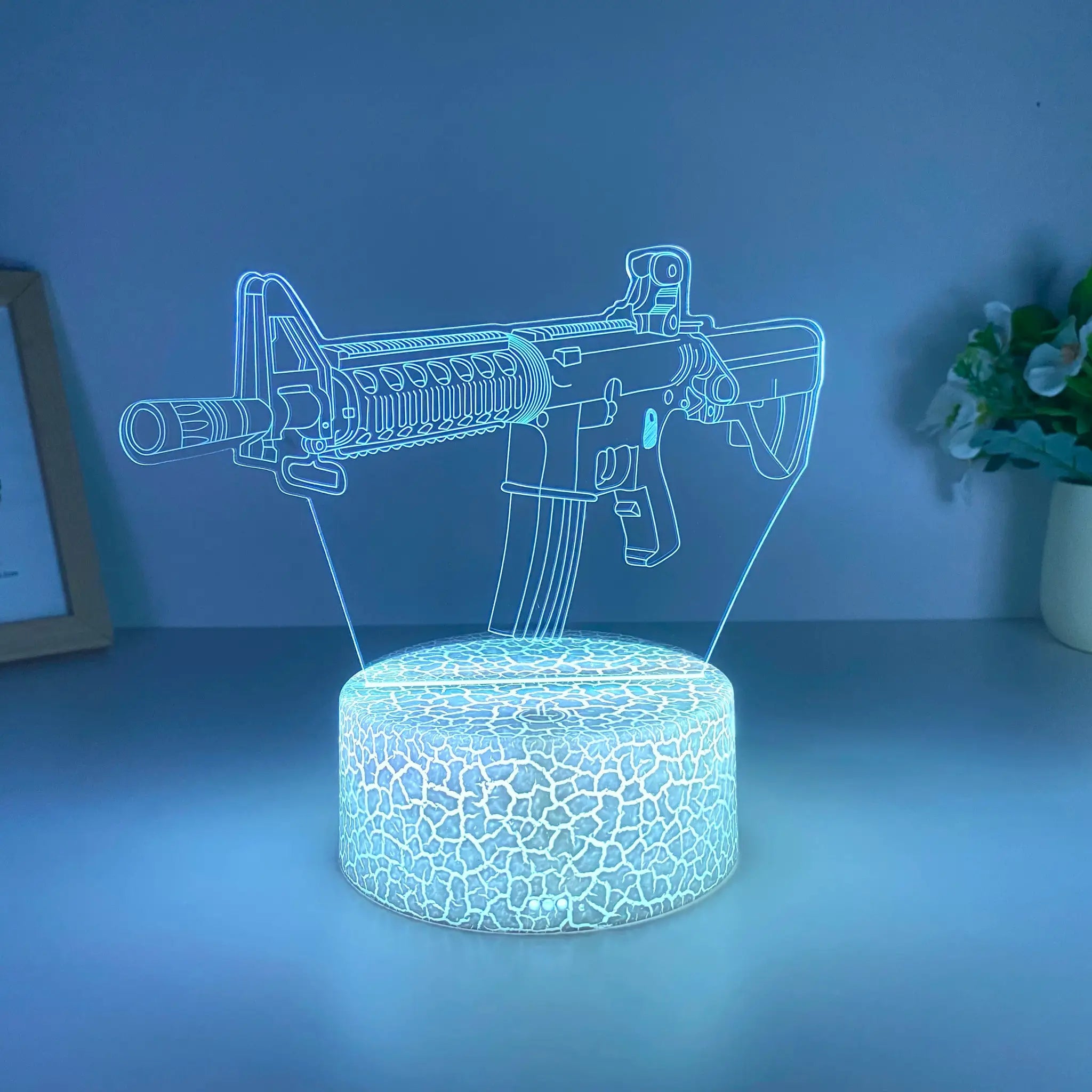 Submachine gun night light in blue LED acrylic with a patterned base by Simples Market.