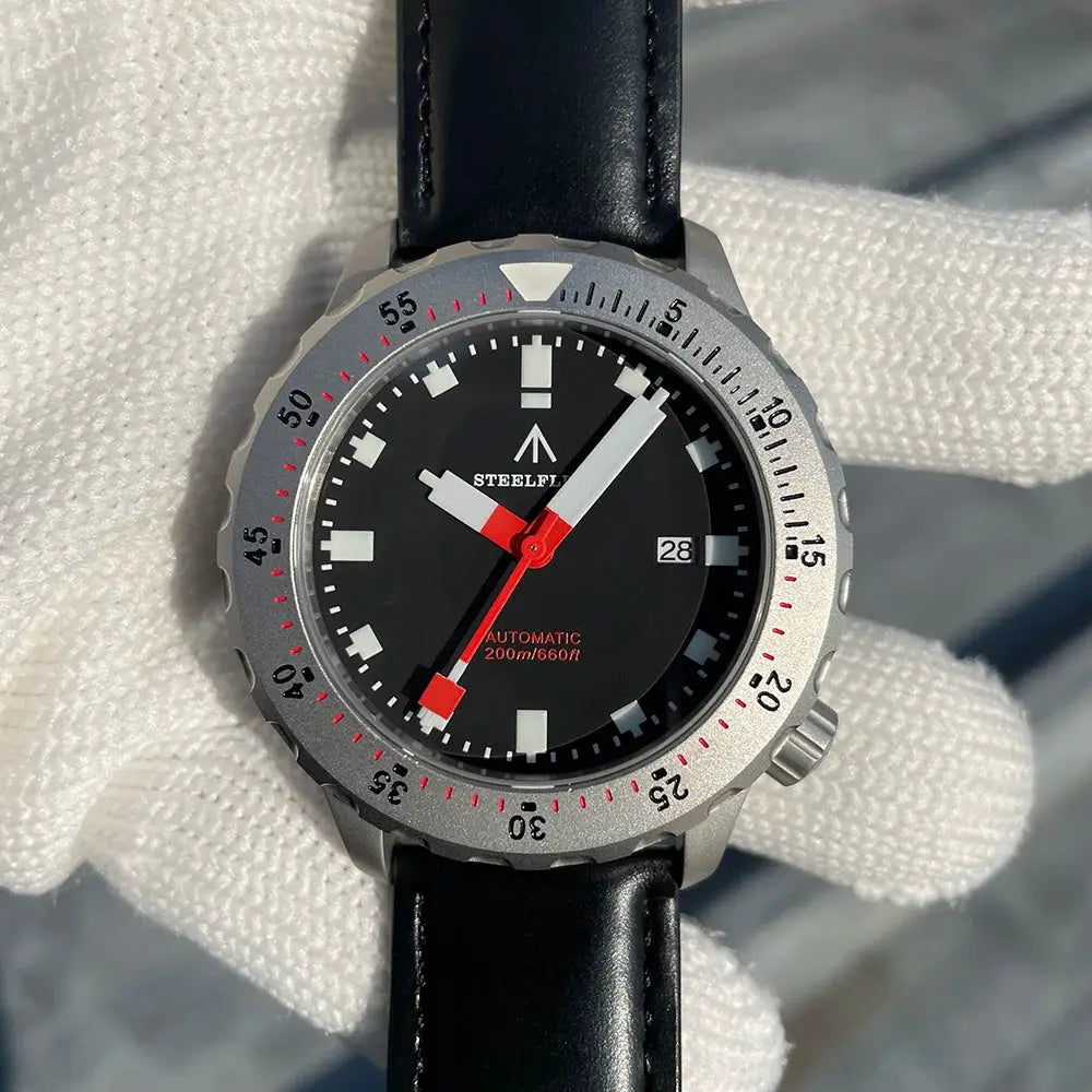 STEELFLIER SF752 wristwatch with black dial, white markers, red accents, date window at 3, gray bezel, black leather strap
