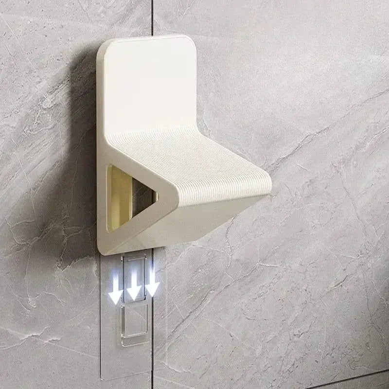 White wall-mounted footstool with ribbed surface and triangular cutout for bathroom use.