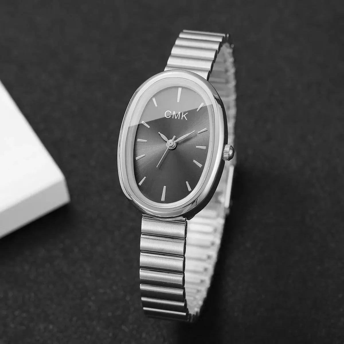 CMK oval-dial women's wristwatch with silver-tone stainless steel band; analog quartz