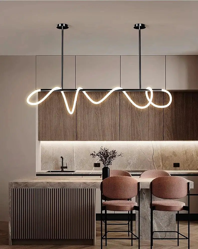 Chandelier pendant light with continuous neon loop design, black ceiling mounts over a modern kitchen island