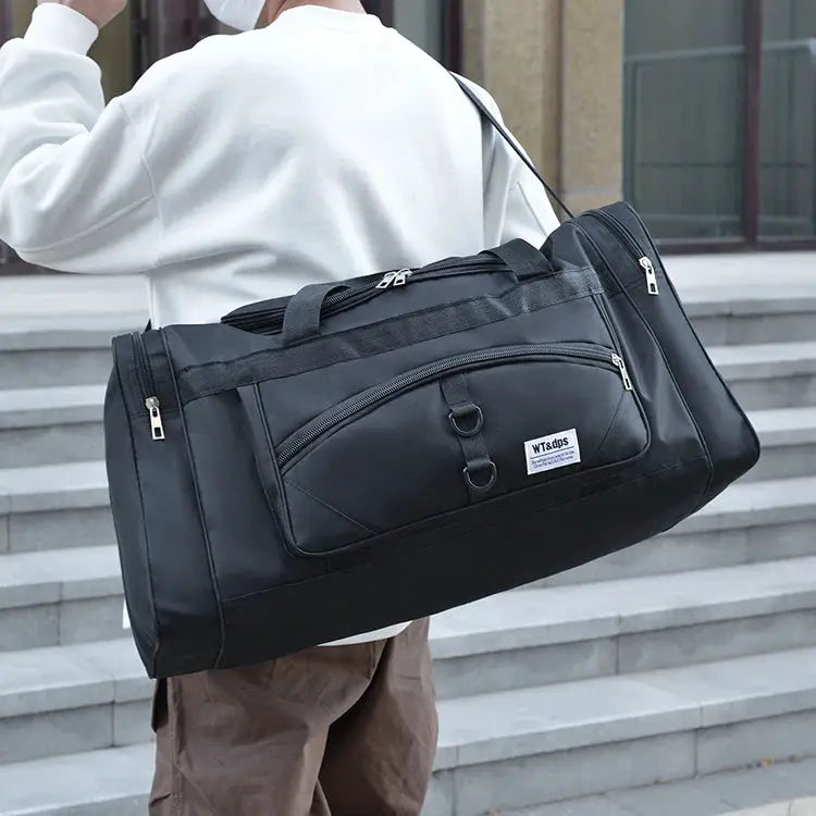 Oversized black duffel bag with multiple zip pockets, carrying handles and shoulder strap for travel, gym and outdoor use